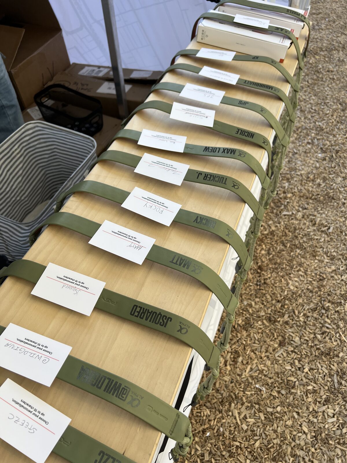 Personalization table lined with name customization cards and straps ready for pressing